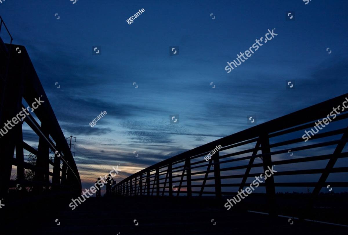 Two cyclists silhouetted against a dusk sky