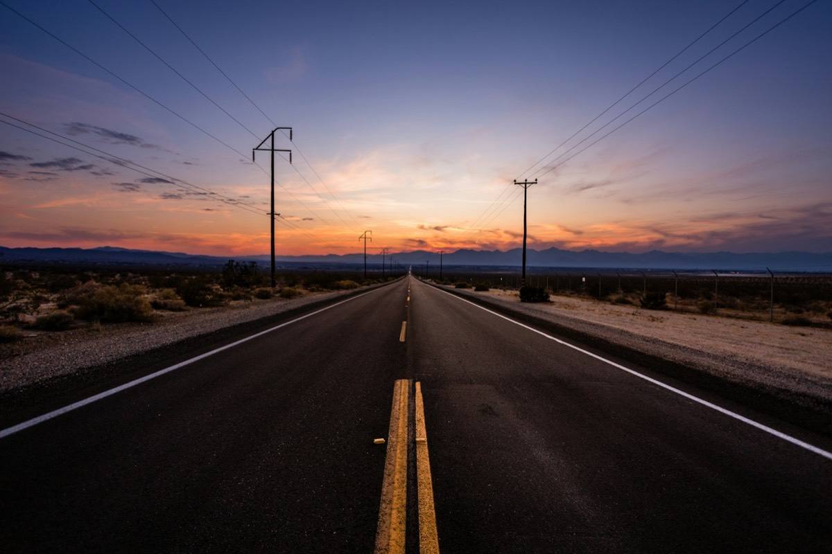 An open road running to the horizon at sunset